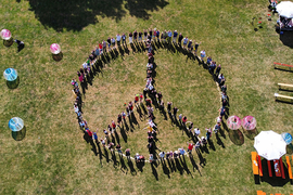 Menschen bilden die Form eines Peace Zeichens am Don Bosco Fest 2022 in Regensburg
